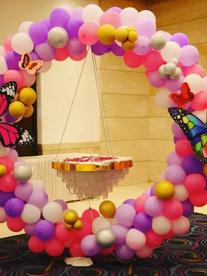 A brightly lit version of our butterfly theme decor. The colorful balloon ring with butterfly accents and the unique hanging cake stand create a magical and memorable setup for a birthday party.