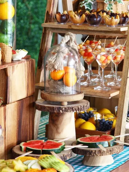 A rustic and abundant fruit station set up on a wooden ladder. This creative display includes fresh watermelon, exotic fruits, and fruit salads, showcasing our flair for presentation.