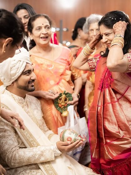 The groom is welcomed with traditional rituals by the bride's family. The smiles and warmth show the happy union of two families.