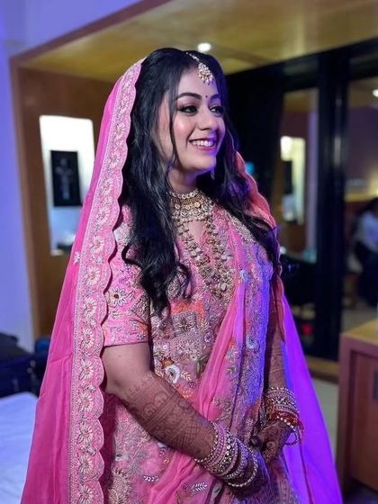 A happy Marwari bride in a beautiful pink lehenga. The soft glam makeup with pink tones perfectly matches her outfit, creating a harmonious and radiant look for her Phera ceremony.