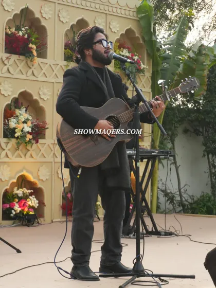 A solo artist performing with his guitar, providing soulful music for the daytime event.