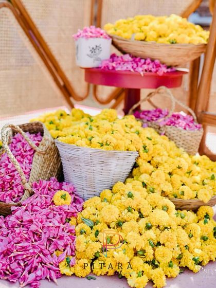 A vibrant Haldi setup with baskets overflowing with yellow marigolds and pink rose petals, ready for the celebration.