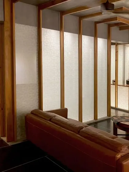 A perspective of the Lucknow penthouse living space, highlighting how the series of wooden frames and illuminated panels creates depth and rhythm, guiding movement through the open plan.