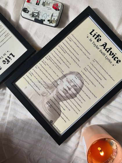 Another angle of the "Life Advice" frame, placed next to a candle and a travel-themed tin. It's a versatile piece of decor that adds a touch of inspiration to any space.