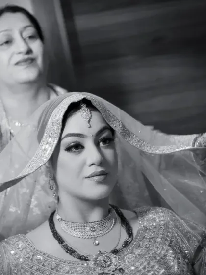 A mother's love as she helps her daughter with the final touches. This black and white photo captures a precious, emotional moment between mother and bride.