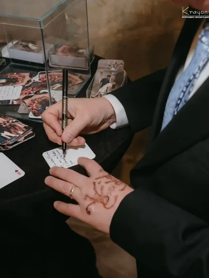 A guest pens a heartfelt message for the couple. These small, personal contributions become treasured keepsakes for years to come.