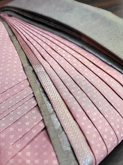 A pre-draped client saree in a lovely pink and grey combination, showcasing the precision of my box folding technique.