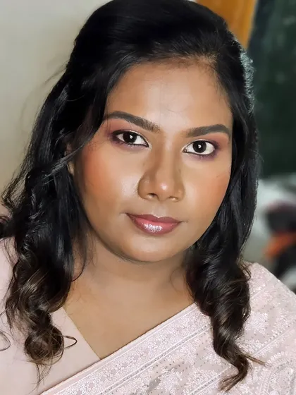A close-up of a reception makeup look, showing the soft pink eyeshadow and glossy lips. The skin has a beautiful, natural glow.