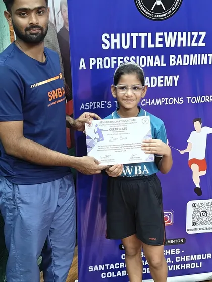 A young player proudly receives her certificate of participation, a key step in building confidence and competitive spirit.