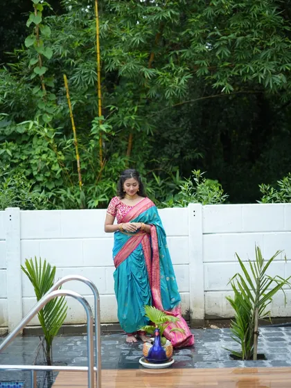 This photo showcases the versatility of the outdoor location, with the client posing by the poolside area. The combination of the traditional Nauvari saree, water, and greenery creates a unique and beautiful image.