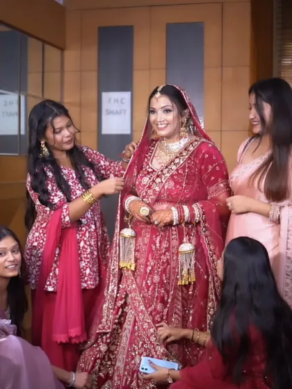 The bride getting ready with the help of her friends and family. It's a beautiful moment of support and love before she walks down the aisle.