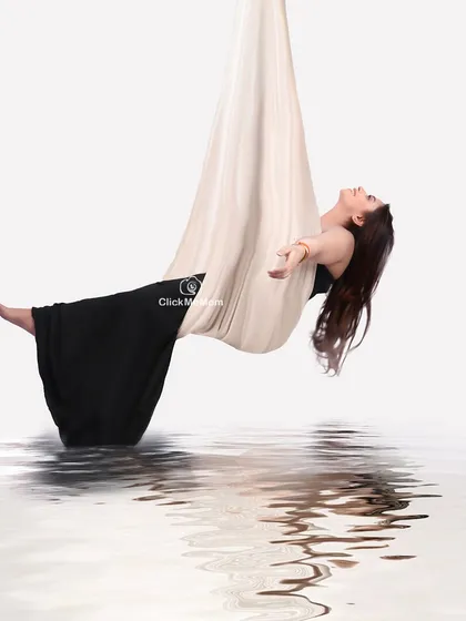 Gracefully suspended. This artistic portrait uses an aerial silk hammock to create a feeling of weightlessness and freedom, with a digital water reflection adding to the surreal and beautiful effect.