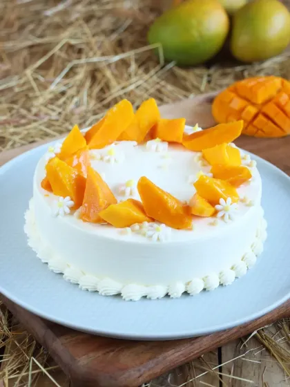 A simple and elegant Fresh Cream Mango Cake, adorned with slices of fresh mango. Sometimes, the simplest presentation is the most beautiful.