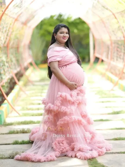 For a soft and romantic feel, this off-the-shoulder pink gown with layers of delicate ruffles is an ideal choice. It drapes beautifully to create a dreamy, ethereal look in any outdoor garden or park setting.