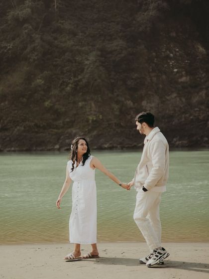 A sweet photo of a couple holding hands by the Ganga, their connection simple and clear.