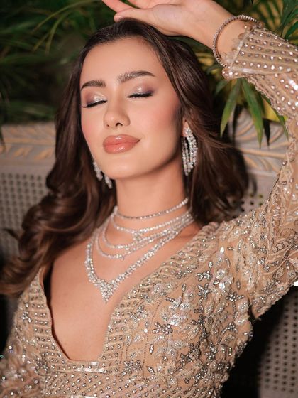 An expressive, eyes-closed shot that highlights the glossy, wet-look eyeshadow. This is a very modern and high-fashion party look.