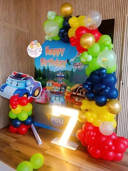 A vibrant Robocar Poli themed birthday party for a 7th birthday, with a custom backdrop and character cutouts.