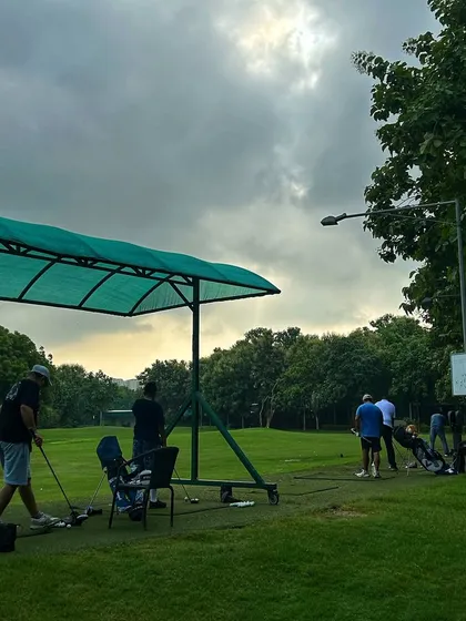 The clouds gather but the practice continues. Golfers enjoying a session under the covered bays.