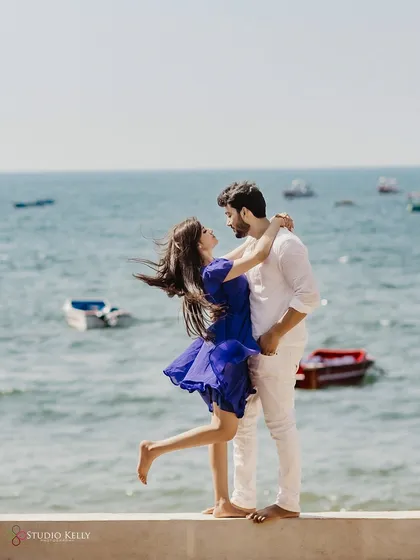 A breezy, romantic moment on the shores of Goa. The wind catching her hair and dress as they embrace by the sea creates a feeling of effortless, natural love.