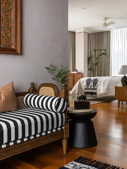 Another shot of the spacious bedroom, highlighting the soft textures, playful patterns, and the way the striped bench complements the soft pink wall.