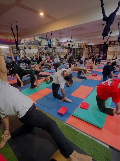 A wide view of our wheel yoga class, with everyone moving in sync. The wheel helps in poses like this modified side plank, adding a balance challenge while supporting the body.