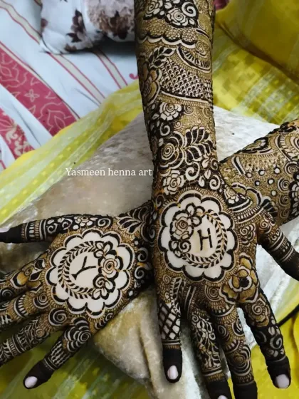 I love weaving your story into my art. For this engagement bride, I designed the mehndi to include her and her partner's initials, 'Y' and 'H', inside elegant floral medallions on each palm.