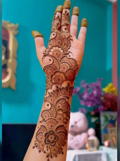 A full-hand Arabic fusion design. The pattern covers the hand and wrist with flowing floral and paisley motifs, offering a dense look that is still very modern.