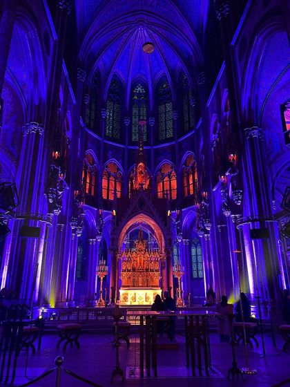 The Votive Church in Vienna, bathed in purple and red light. This image showcases the incredible transformation of a historic space through modern art.