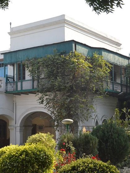 The balcony before restoration, its beautiful details hidden under layers of peeling green paint and decay.