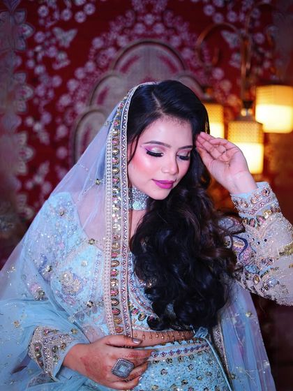 A close-up portrait that highlights the soft glam makeup and the intricate details of the outfit.