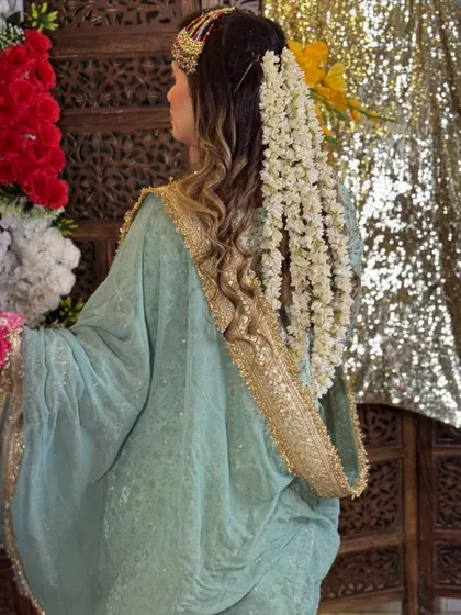 A back view of the stunning floral hair accessory, a cascade of white flowers woven into her soft curls.