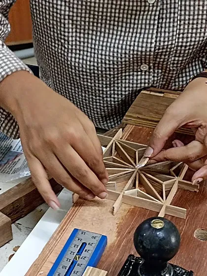 The heart of Kumiko is in the hands. Here, I'm carefully fitting together small, precisely cut pieces of wood to form the traditional Asa-no-ha pattern. This nail-free technique requires patience and a deep respect for the craft.