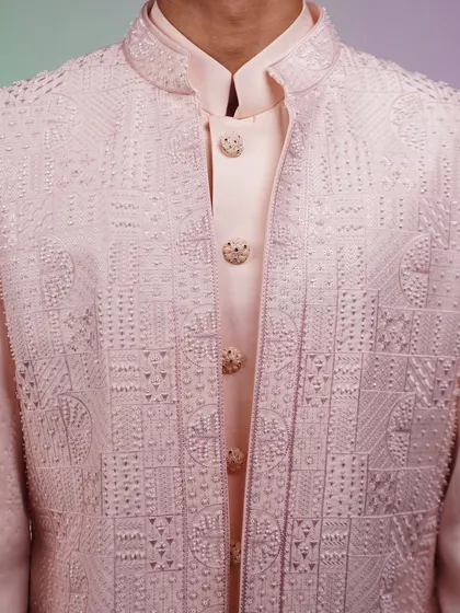 A close-up of the intricate embroidery on our pastel pink Indo-Western jacket. The detail is what sets our collection apart.