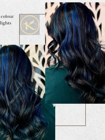 A stunning look with deep blue highlights on black hair. The hair is styled in curls to make the blue streaks pop and create a dramatic effect.