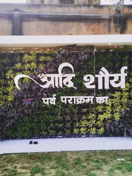 The event-specific living wall in daylight, with the custom Hindi lettering clearly visible against the green and purple plants.