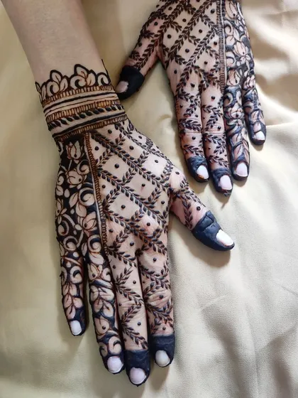 A minimal back-hand design for a bride, featuring a beautiful net pattern and floral border.
