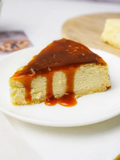 A slice of classic cheesecake with a generous drizzle of caramel sauce. The clean background and focus on the dripping sauce make this an incredibly tempting shot.