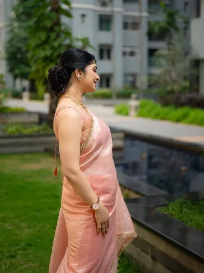 A candid portrait of actress Aditi Prabhudeva in a peach-colored saree. Her natural expression and the soft outdoor lighting create a gentle and approachable image.