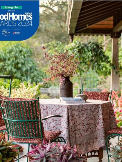 An outdoor dining table on the veranda, surrounded by lush gardens. This is the essence of slow living, where meals are enjoyed in the open air, connected to the sights and sounds of the Coorg landscape.