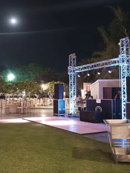 The DJ console and dance floor setup for an outdoor reception, showing the truss and lighting rig.