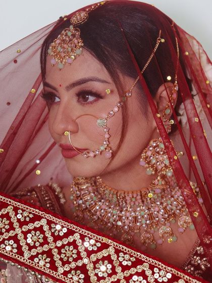A side profile view that highlights the contouring, eye makeup, and the intricate details of the nath and maang tikka.