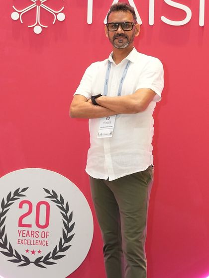 A confident stance in front of the TAISI conference branding. This represents my commitment to being a voice for parenting partnerships within the larger landscape of international school education in India.