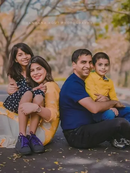 A beautiful family of four posing for a portrait on a tree-lined road in Cubbon Park. Outdoor family photoshoots allow for natural, relaxed images that capture your family's personality.