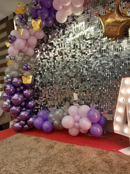 The anniversary setup with the addition of a large, light-up marquee number '4'. The 'Happy Anniversary' neon sign glows against the sparkling backdrop.