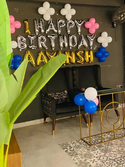 A simple wall decoration for a first birthday. This setup uses foil balloons to spell out the name and wish, with small balloon clusters for a pop of color.