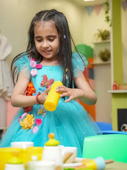 A beautiful princess in a blue gown playing in our pretend kitchen area.