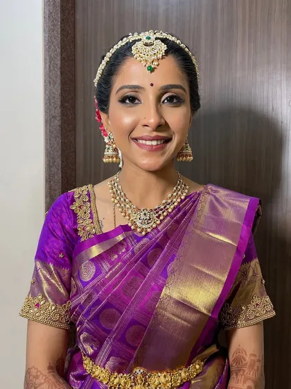 A classic bridal portrait. The makeup is fresh and clean, with a focus on enhancing her features without looking heavy, perfect for a daytime Muhurtham ceremony.