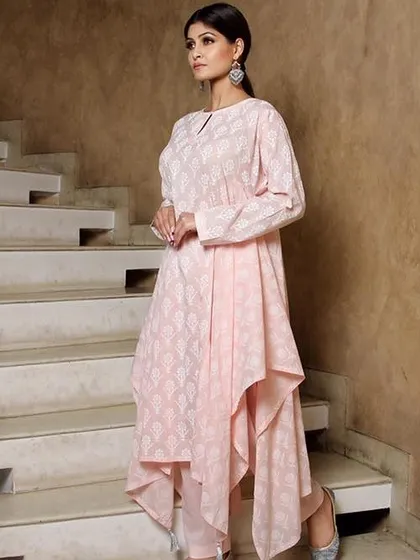 A model wearing a modern, asymmetrical pink kurti set, posed on a staircase. This demonstrates my ability to shoot on location or with more complex backgrounds.
