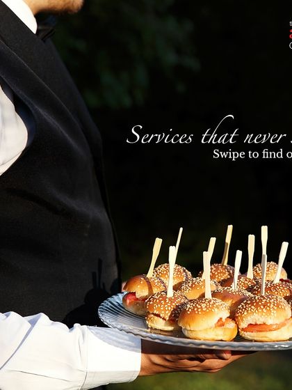 Our staff serving mini burgers at an outdoor event. We cater to high-teas, corporate gatherings, and launch events with a wide range of bite-sized snacks and appetizers.