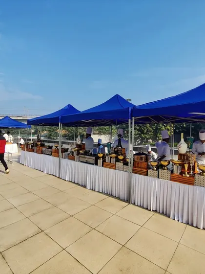 We provide practical solutions for outdoor events, such as these canopied buffet stations. They protect the food and add a professional touch to the catering area on this open terrace.